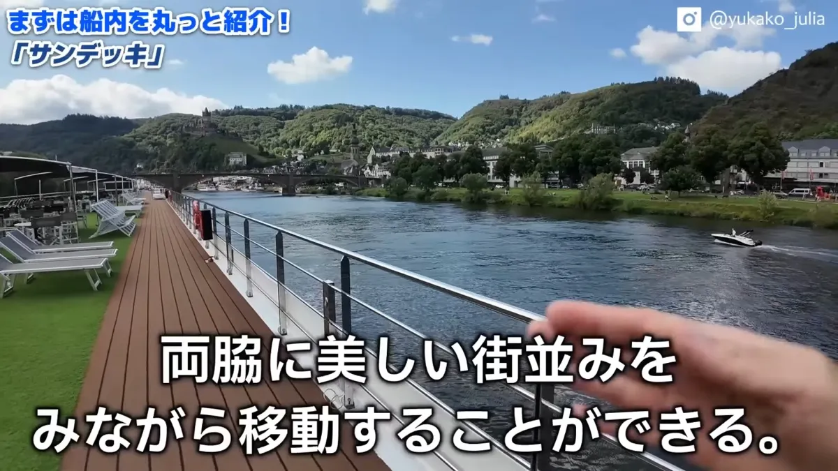 サンデッキから見る川沿いの街並みと緑の丘